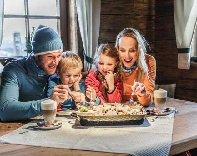 Familie genießt Kaiserschmarrn in der Skihütte.