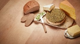 Cheese and bread on top of a wooden table